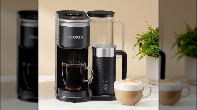 Máquina Keurig K-Supreme Plus con una taza llena de café y un café con leche