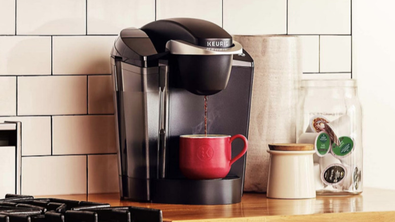 Cafetera Keurig K-Classic sirviendo café en una taza de café roja