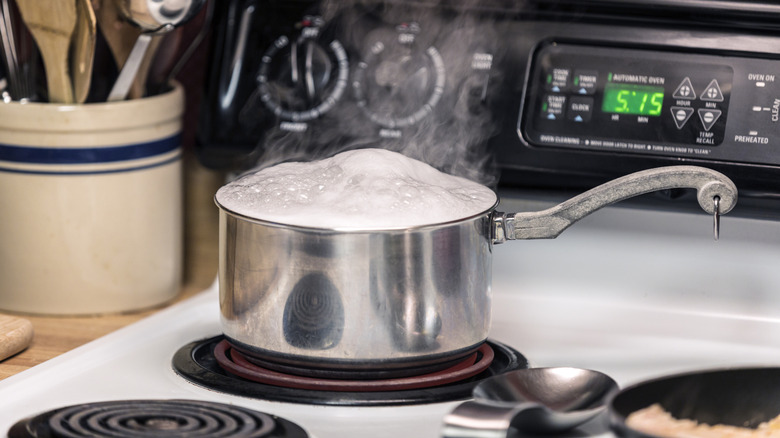 Olla de cocción en estufa eléctrica con agua hirviendo