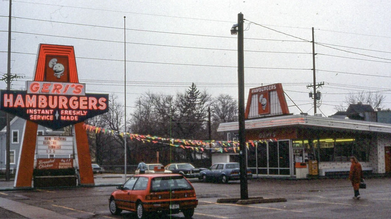 Toma de la ubicación de Geri's Hamburgers que muestra el estacionamiento, el letrero y el exterior del restaurante.