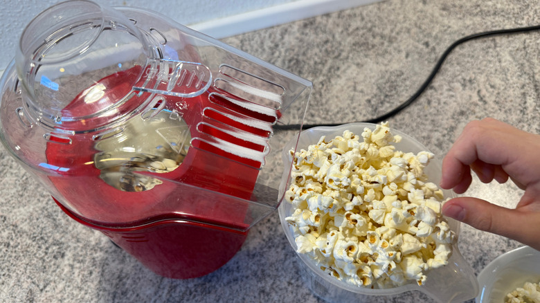 Vista aérea de un popper rojo con una taza de palomitas de maíz al lado