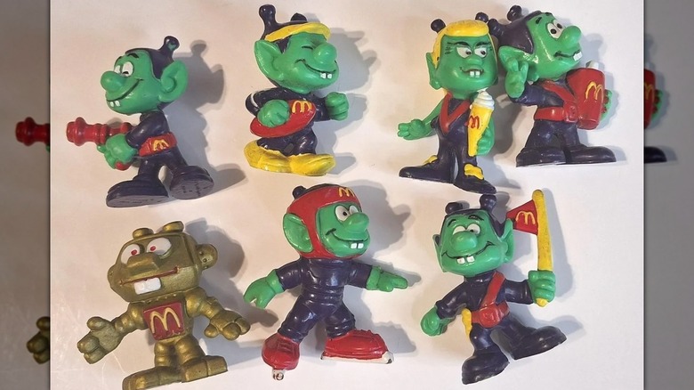 Siete figuras de Astroniks sobre un fondo blanquecino