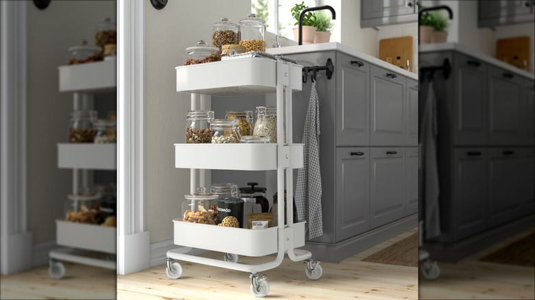 Carro utilitario Råskog blanco utilizado para almacenar refrigerios móvil al final de un mueble de cocina