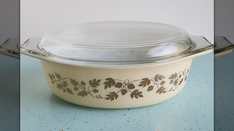Un plato de Pyrex vintage con un patrón de hojas doradas y bellotas.