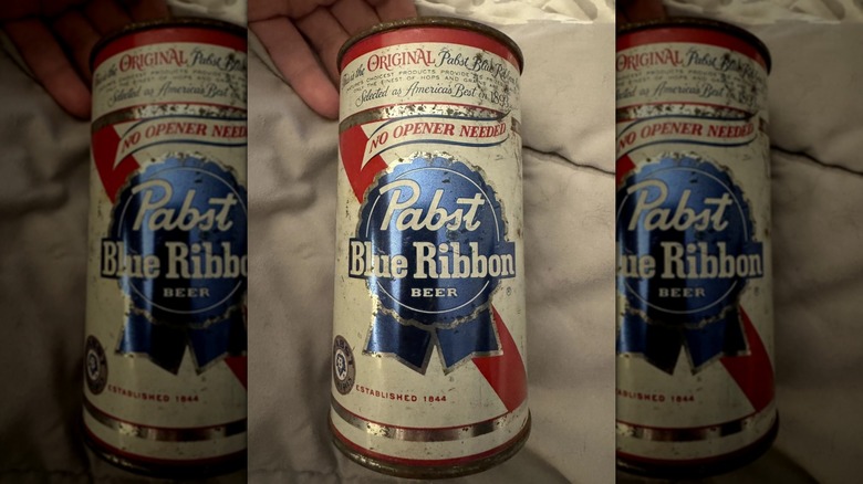 Una lata Pabst Blue Ribbon tumbada sobre una manta