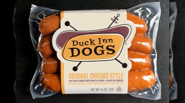 Estilo Chicago original de Duck Inn Dogs en el paquete sentado sobre un fondo negro.