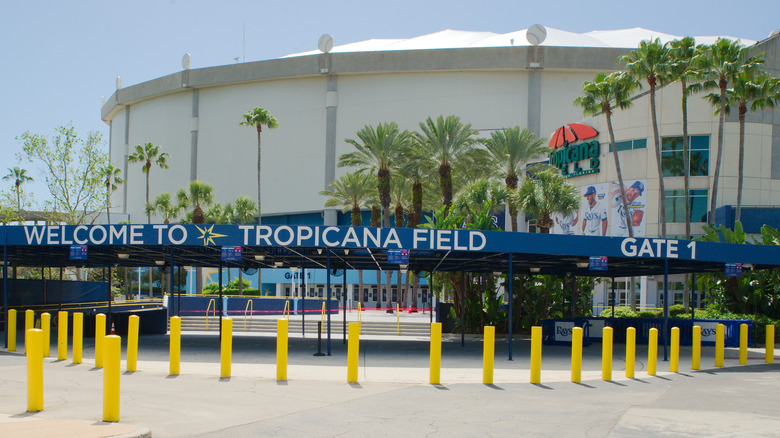 Una vista exterior del Tropicana Field en San Petersburgo, Florida, con palmeras afuera y la entrada a la Puerta 1