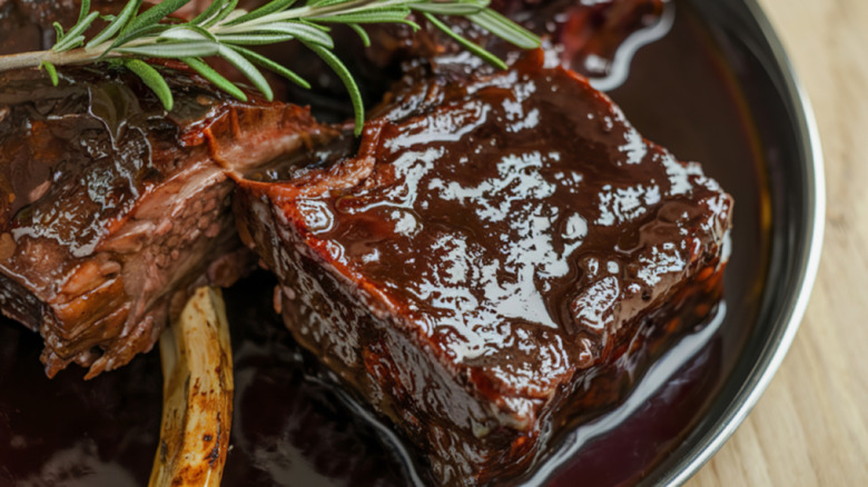 Costillas estofadas en salsa de vino tinto con una ramita de romero