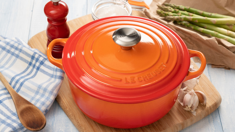 Maceta Le Creuset en color Flame sobre tabla de cortar madera