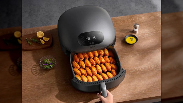 Cajón del horno Typhur Dome 2 abierto con alitas de pollo forradas en su interior