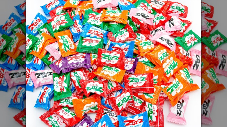 Varios sabores de caramelos ZotZ en un montón sobre un fondo blanco.