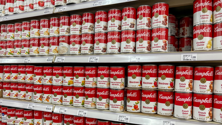 Varios estantes de tiendas llenos de distintos sabores de sopas Campbell's.
