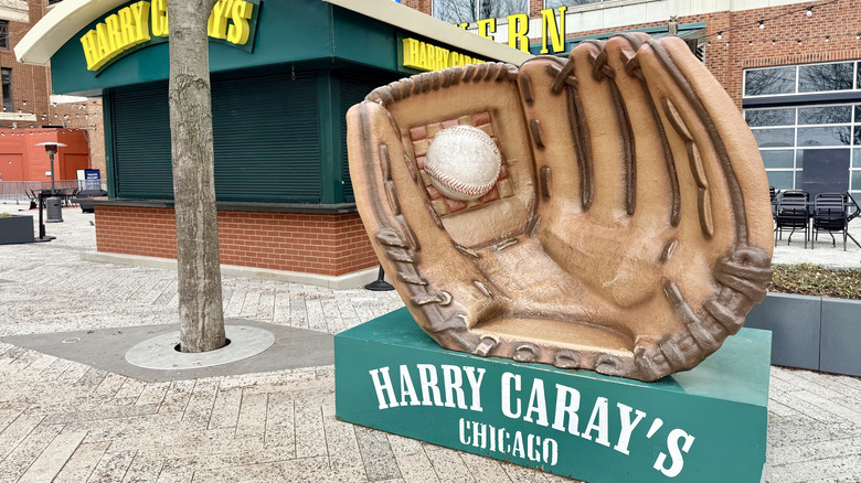 Un cartel de Harry Caray's con una gran estatua de un guante de béisbol.