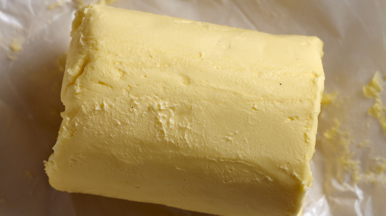 Un rollo de mantequilla Amish sobre papel pergamino.