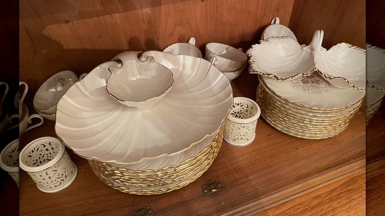 China en un estante con el patrón Lenox Orleans, incluidos platos y fuentes para servir