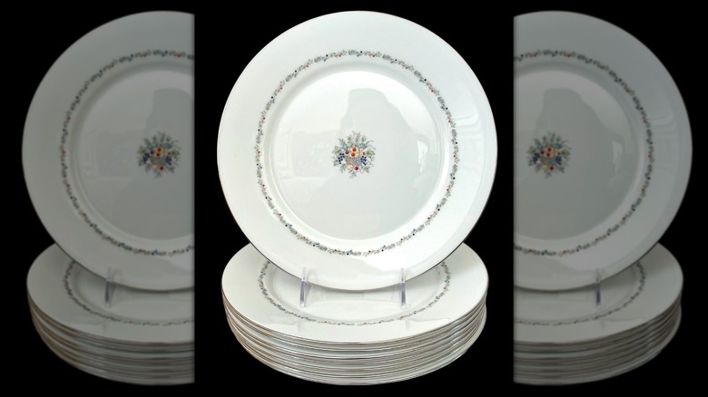 Un plato con el patrón Lenox Carlyle encima de una pila de otros platos con el patrón Carlyle