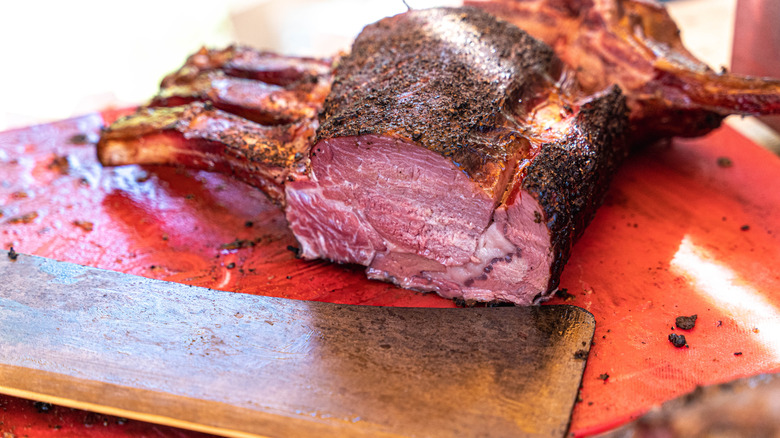 Costilla en rodajas sobre tabla de cortar con cuchilla