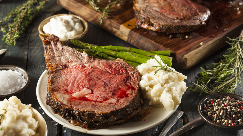 Prime rib en un plato con puré de patatas y espárragos